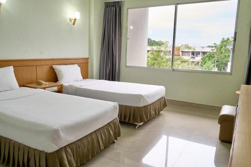 a hotel room with two beds and a window at Yala Rama Hotel in Sathani Yala