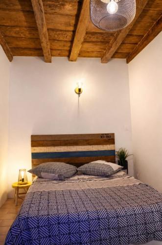 a bedroom with a large bed with a wooden ceiling at Charmant appartement climatisé en plein coeur du village et proche des plages avec wifi in Cervione