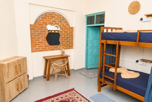 a room with two bunk beds and a table at Dreamy Hostel Arugambay in Arugam Bay