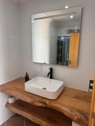 a bathroom with a white sink and a mirror at O Cantinho dos Avós in Mourão