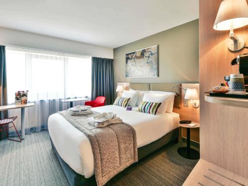 a hotel room with a bed and a desk at Mercure Périgueux Centre Historique in Périgueux