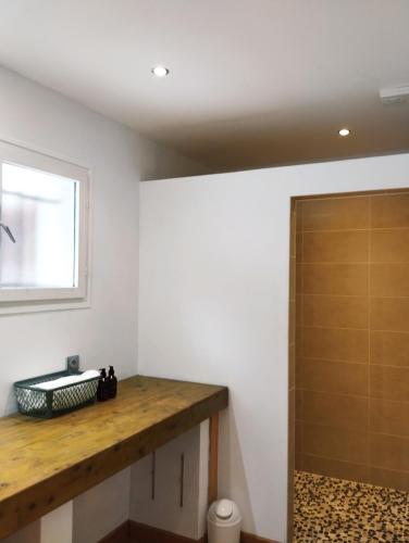 a bathroom with a wooden counter and a shower at Chez Nanard et Lili in Bec-de-Mortagne