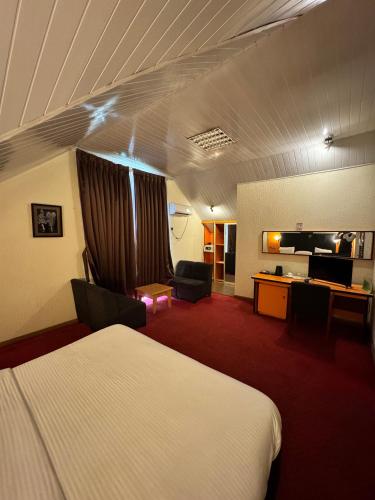 a hotel room with a bed and a desk at Royalbirds Motel in Akure