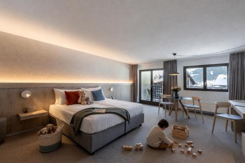 a child sitting on the floor in a hotel room at Victoria Hotel & Residence in Villars-sur-Ollon