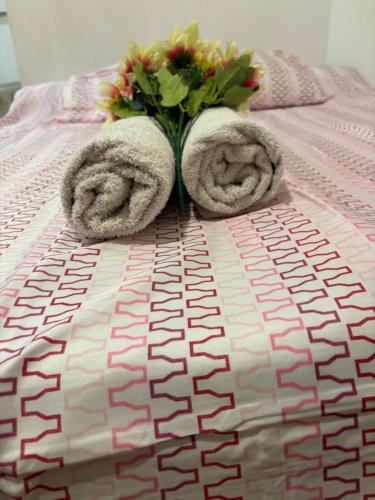 a vase with flowers and towels on a bed at MK VALeNCIA in Valencia