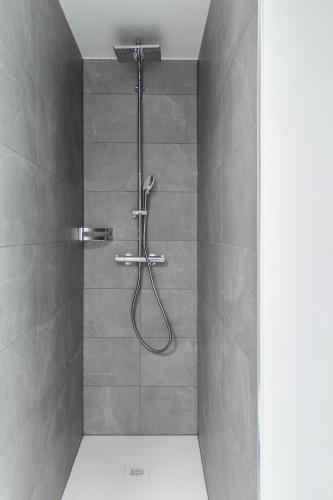 a shower with a hose in a shower stall at By THE LAKE in Muralto