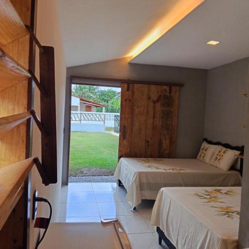a bedroom with two beds and a large window at Brisa Oceanica in Itarema