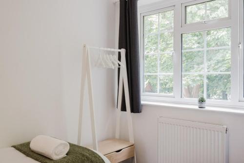 a white room with a window and a bed at Spacious 4-Bed Home with Free Parking in Northampton