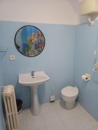 a bathroom with a sink and a toilet and a mirror at Hostal Amanecer in Fuentebureba
