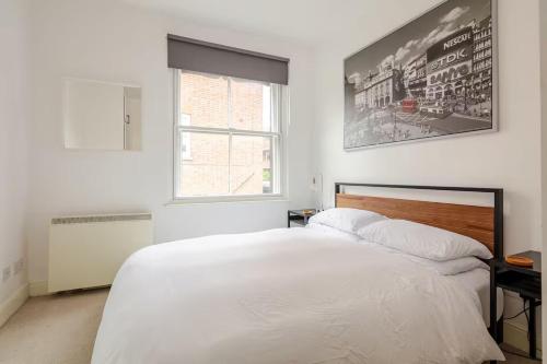 a bedroom with a white bed and a window at Entire 1 Bed Central Flat - St Albans in St. Albans