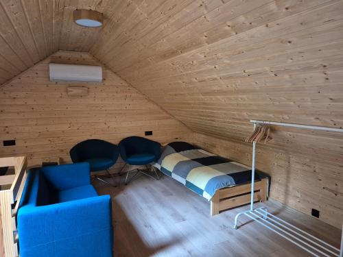 a bedroom with a bed and two chairs in a room at Le Rond Point in Sieraków