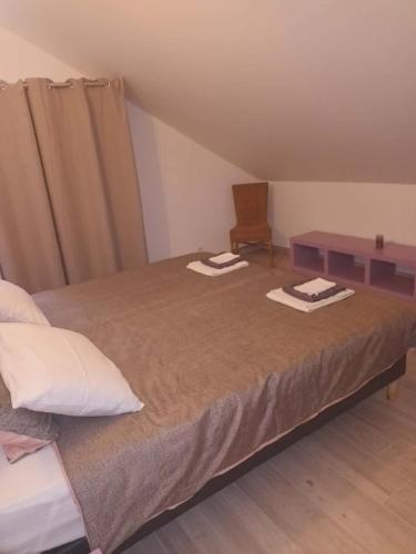 a bedroom with a bed with two towels on it at Gîte aux 3 Cep in Magnien