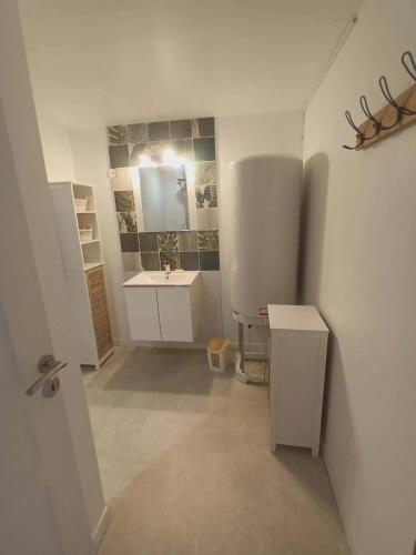a white bathroom with a sink and a mirror at Gîte aux 3 Cep in Magnien