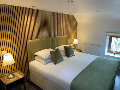 a bedroom with a large white bed with two pillows at Millers Cottage in Llandysul