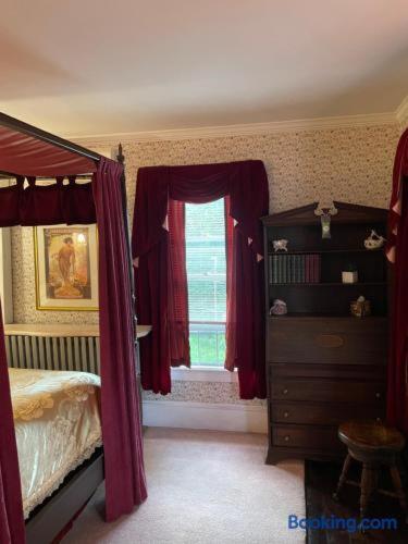 a bedroom with a bed and a window with red curtains at Hillcrest Bed and Breakfast in Jim Thorpe