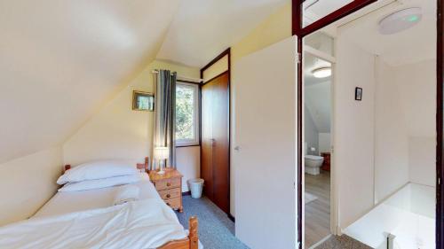 a attic bedroom with a bed and a mirror at 87 Strawberry Hill, Tolroy Manor in Hayle