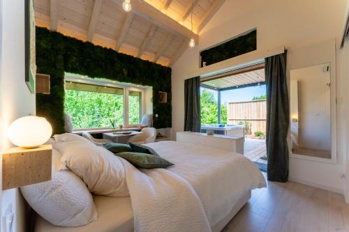 a bedroom with a large bed and a large window at EPIC CHALETS - 4 et 5 étoiles - Spa privatif - Gérardmer in Granges-Aumontzey