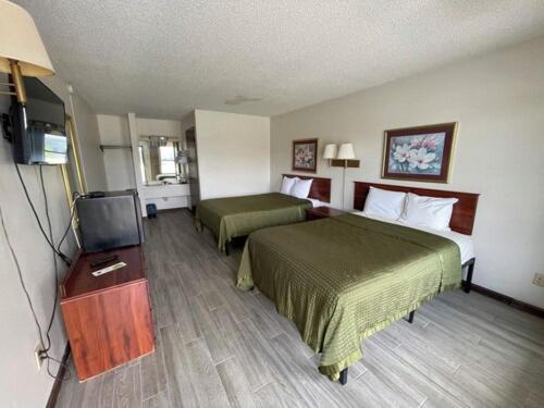 a hotel room with two beds and a flat screen tv at Gateway Inn in Lake City