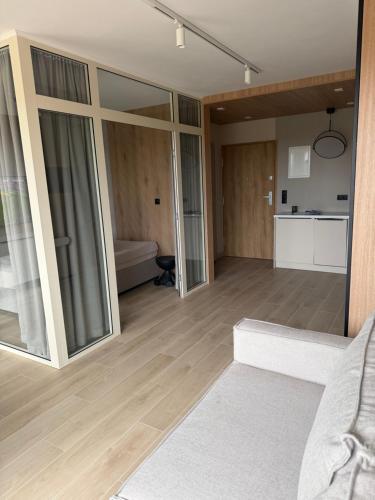 a living room with sliding glass doors and a couch at Apartament Sosnowy 45 in Rowy