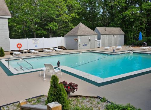 a large swimming pool with a fence around it at Sea Spark - Cape Escape with Pool Access in Mashpee