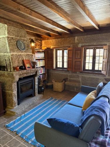 a living room with a couch and a fireplace at Casa do Campo in Montalegre
