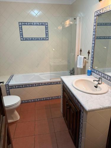 a bathroom with a sink and a tub and a toilet at Casa do Campo in Montalegre