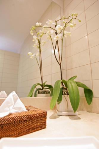 a bathroom counter with a vase with white flowers in it at Villa Salobre Master and Sun in Maspalomas