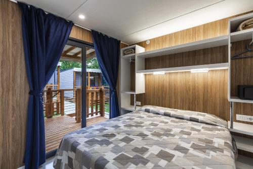 a bedroom with a bed and a balcony at Camping Village Du Parc in Lazise