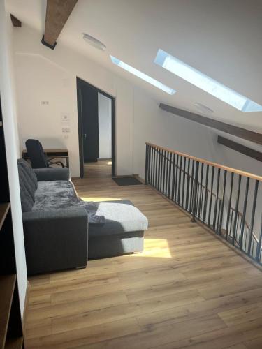 a living room with a couch and a staircase with skylights at Central View Penthouse & Parking in Târgu-Mureş