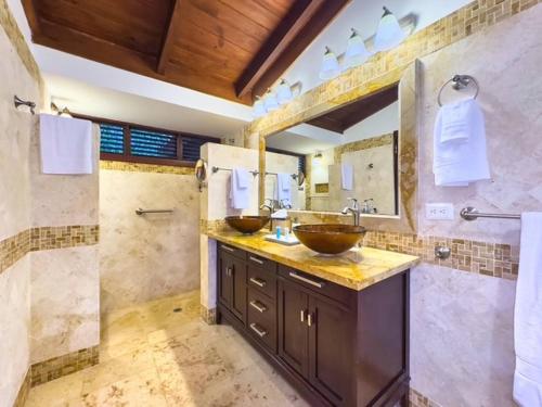 a bathroom with two sinks and a shower at Las Margaritas, Casa de Campo in La Romana
