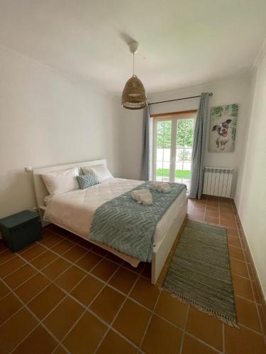 a bedroom with a bed and a window at Casa Lesarlo - T3 luxury, garden, pool - Praia D'El Rey in Casal da Lagoa Seca
