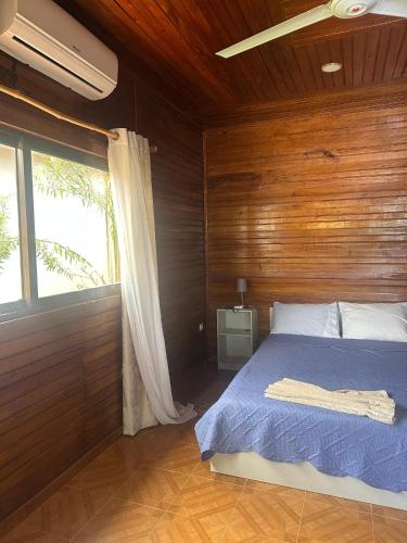 a bedroom with a bed with a wooden wall at EcoResorTamarino in M. Peixe