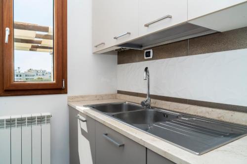 a kitchen with a sink and a window at Appartamento dell'Aurora by Le Dune Villas in Porto Cesareo
