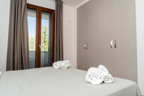 a bedroom with a bed with towels on it at Appartamento dell'Aurora by Le Dune Villas in Porto Cesareo