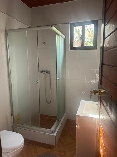 a bathroom with a shower and a toilet and a sink at EcoResorTamarino in M. Peixe