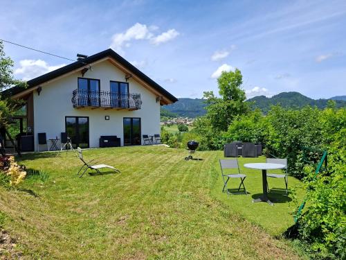 a house with a yard with a table and chairs at Murka Holiday Home in Bled