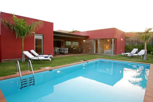 a swimming pool in front of a house at Villa Salobre Master and Sun in Maspalomas