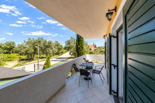a balcony with a table and chairs on it at Nikos Villas - Poolside Getaways in Kavos, Corfu in Kavos