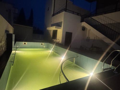 a tennis court with green lighting in a building at JSP OLIVE NEST villa in Yelagiri