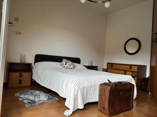 a bedroom with a bed and a suitcase at Spacious Apartment 20min from Piazza Maggiore in Bologna