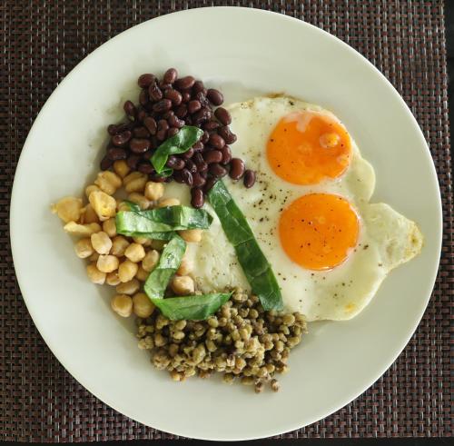 a plate of food with eggs and beans on a table at Aji fruit farm cottage peaceful lakeside farm stay with sunrise views 03 in Embilipitiya