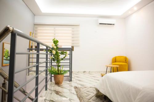 a bedroom with a bed and a yellow chair at SARALIS Home in Abidjan