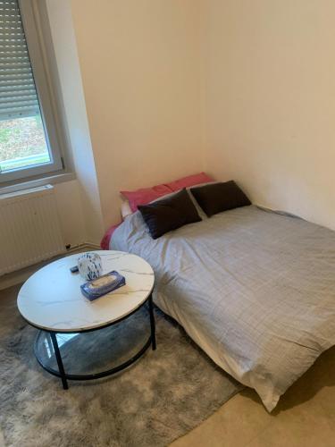a small bedroom with a bed and a table at Ancrage home in Montargis