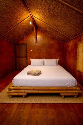 a bedroom with a bed in a wooden room at Ocean Fresh Surfhouse in Pulau Sarang