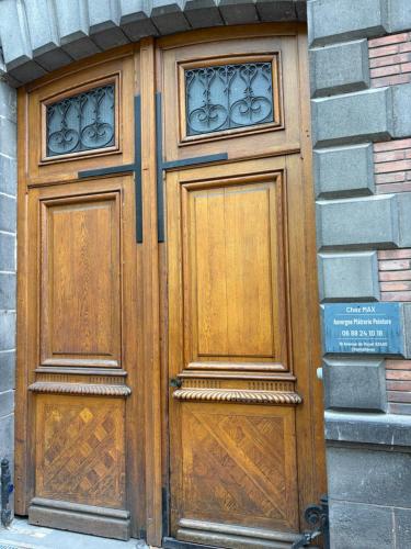 a wooden door with two windows on a building at Sweety Room in Chamalières