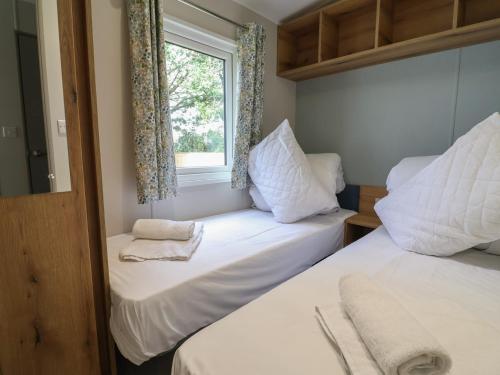 two beds in a small room with a window at The Oaks 2 Bedrooms in Northwich