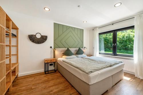 a bedroom with a bed and a large window at Design-Apartment mit Garten in Langenbach