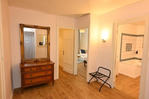 a room with a mirror and a dresser and a bathroom at Grand Hôtel de l'Europe - Morlaix Centre in Morlaix