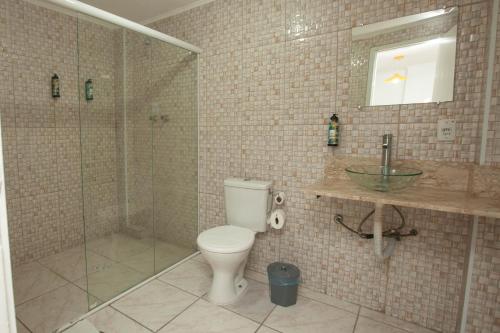 a bathroom with a shower and a toilet and a sink at Gru Inn Hotel in Guarulhos