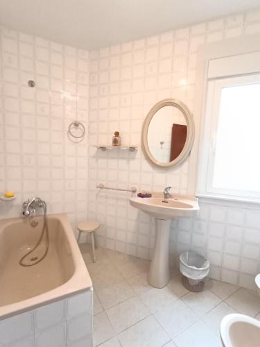 ein weißes Badezimmer mit Badewanne, Waschbecken und Badewanne in der Unterkunft A Esteva in Orol